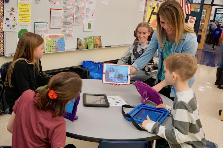 <p>Allie’s speech therapist, Kristin Dean, sharing a photo of Allie’s dog Sadie with GMS students.</p>
